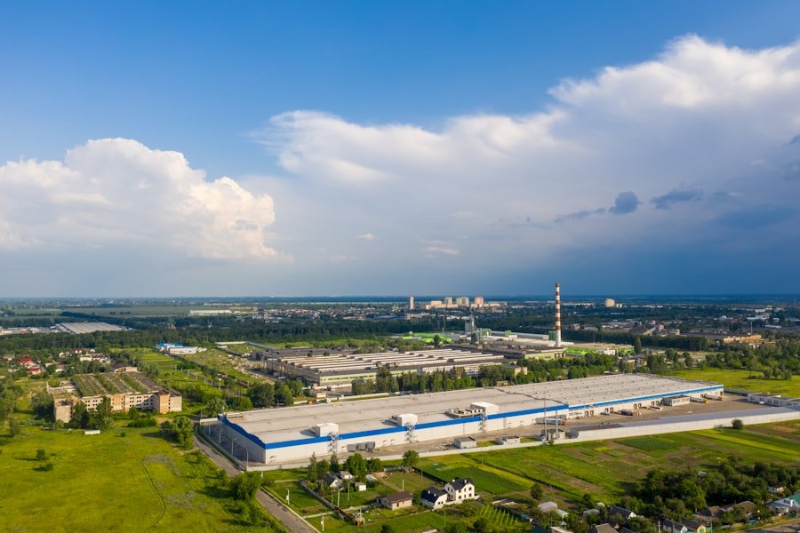 Galpão industrial visto de cima, cercado por área verde